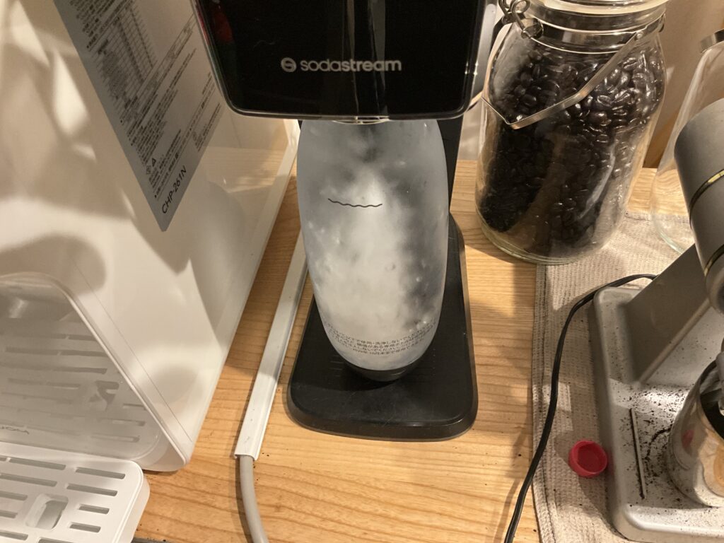 ウォータースタンドから注いだ水をソーダストリームで炭酸水に変える画像です。